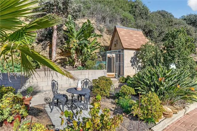 a patio with table and chairs and potted plants