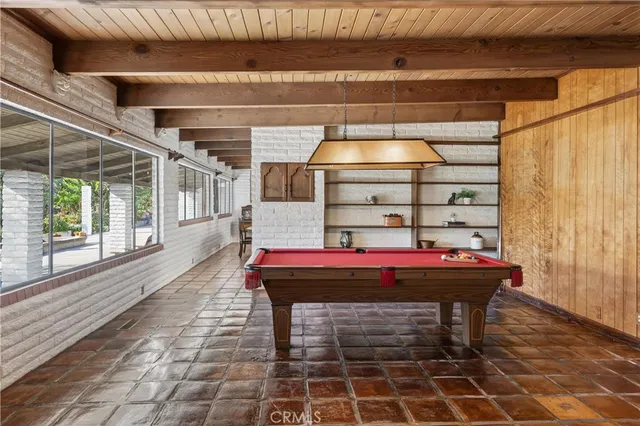 a room with pool table and windows