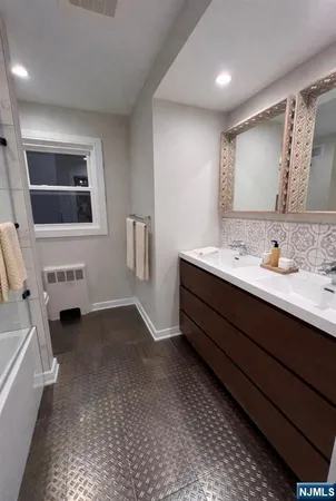 a spacious bathroom with a double vanity sink and a mirror