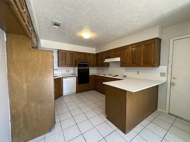 a kitchen with a sink a counter top space and cabinets