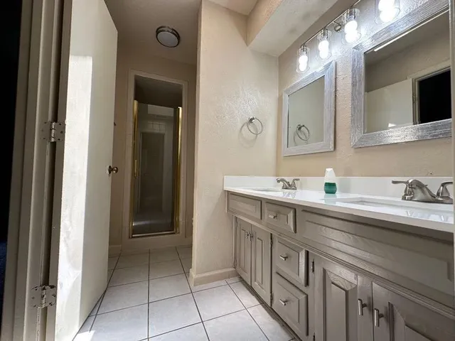 a spacious bathroom with a double vanity sink and a mirror