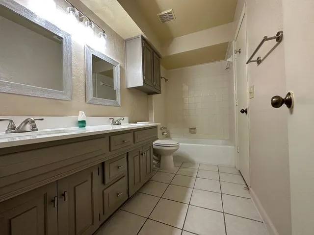 a bathroom with a double vanity sink toilet mirror and shower