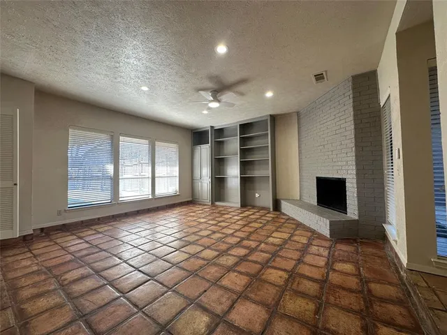a view of an empty room with a fireplace and a window