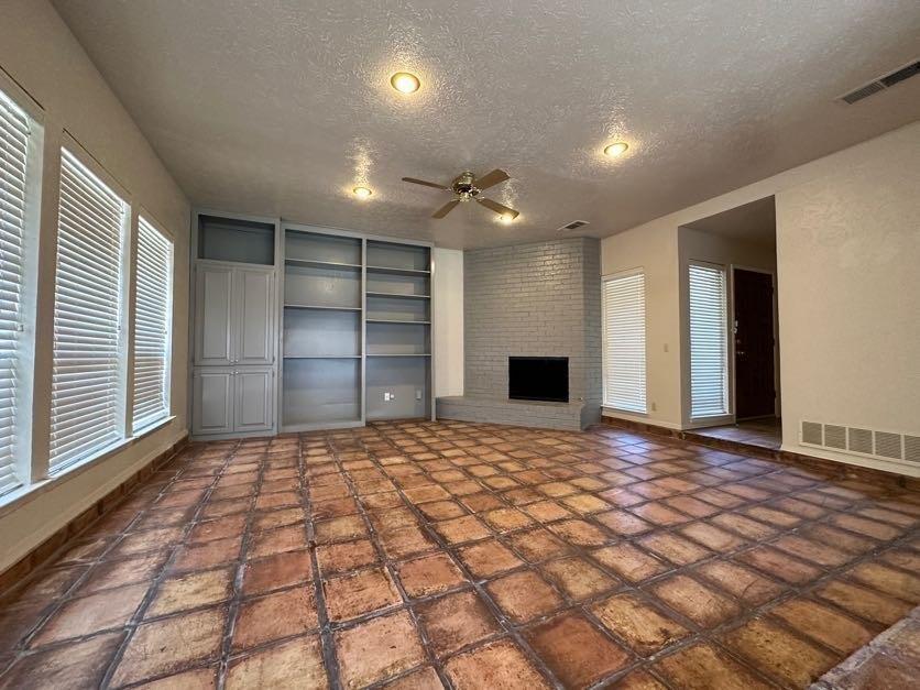 1900 Tree House Lane Plano, TX 75023 - Photo 4 of 18 a view of an empty room with a fireplace and a window