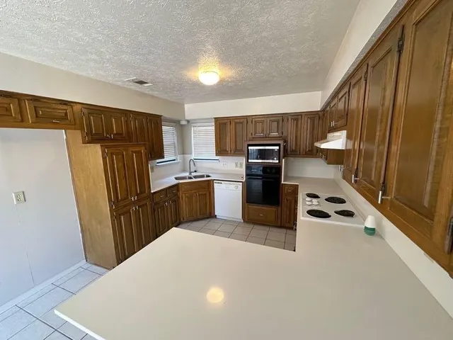 a kitchen with sink refrigerator and microwave