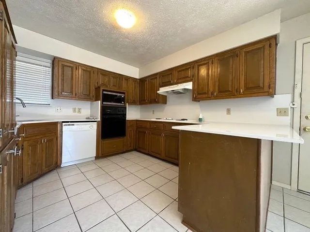 a kitchen with a refrigerator sink and cabinets