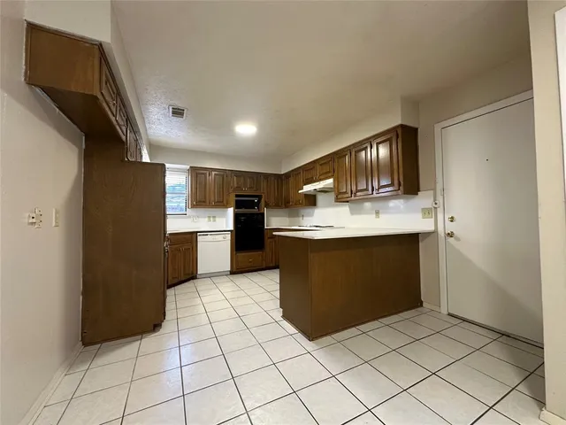 a view of an empty room with a chandelier fan