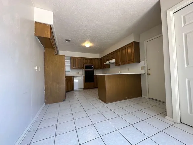 a view of kitchen with refrigerator cabinets and microwave