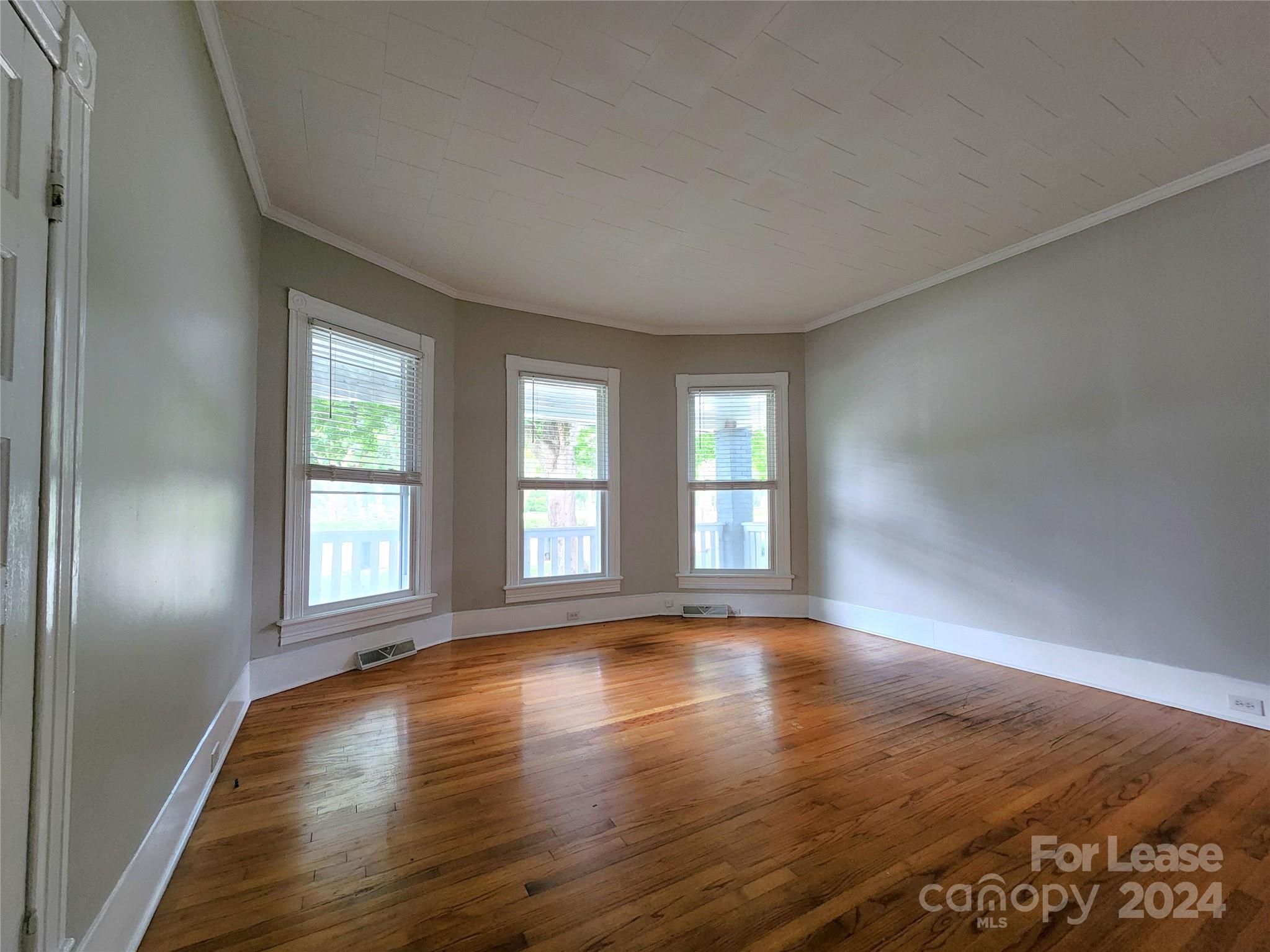 1126 South Fulton Street, Unit B Salisbury, NC 28144 - Photo 4 of 17 a view of an empty room with wooden floor and a window