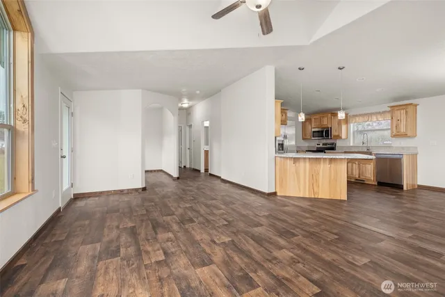 a view of an empty room with a window and wooden floor