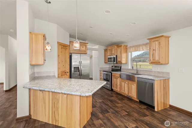 a kitchen with stainless steel appliances granite countertop a sink stove and microwave