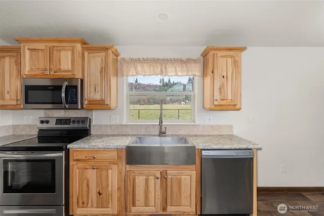 a open kitchen with granite countertop a sink and dishwasher with wooden floor