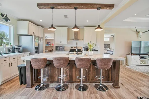 a kitchen with stainless steel appliances granite countertop a kitchen island a stove a table and chairs in it