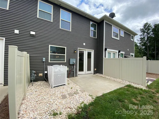 a backyard of a house with white walls