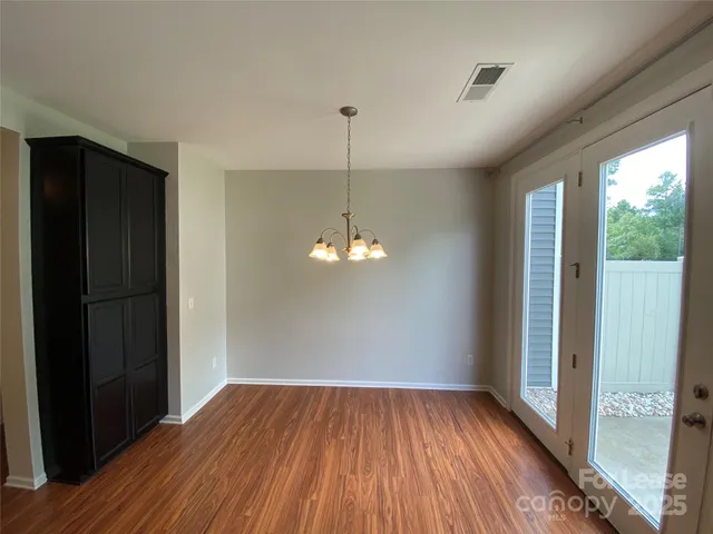 a view of a room with wooden floor fan and window