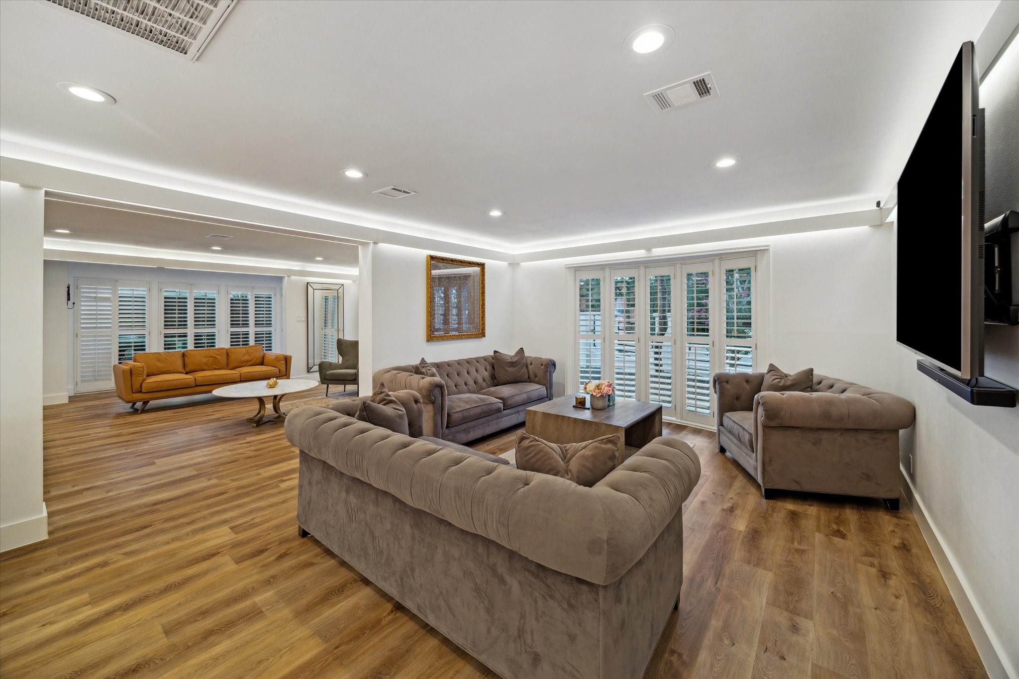 6321 Deerwood Road Houston, TX 77057 - Photo 8 of 34 Expansive living space with wood-look flooring, plantation shutters and sleek recessed accent lighting.