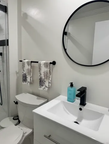a bathroom with a sink mirror and toilet