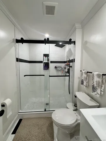 a bathroom with a granite countertop sink toilet and shower