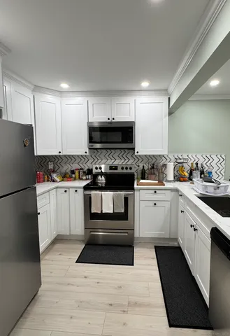 a kitchen with granite countertop a refrigerator stove top oven and sink