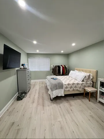 a bedroom with a bed a couch and a flat screen tv