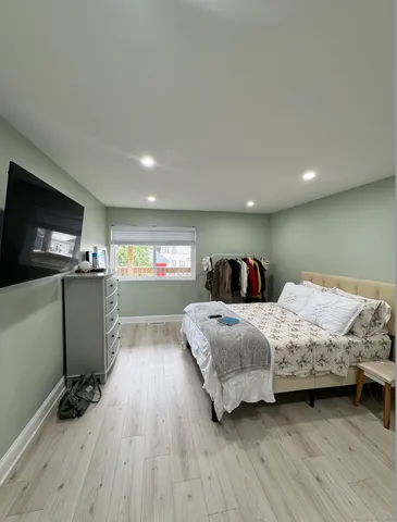 a bedroom with a bed and a flat tv screen on dresser
