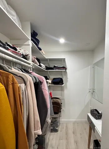 a view of walk in closet with clothes and shoes