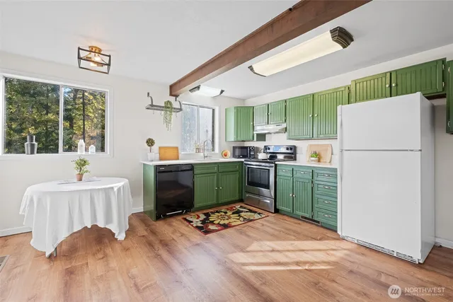 a kitchen with a refrigerator and a stove top oven