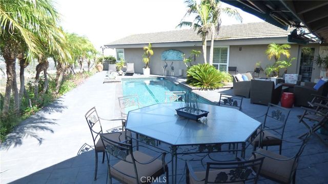 a patio with a table and chairs and potted plants