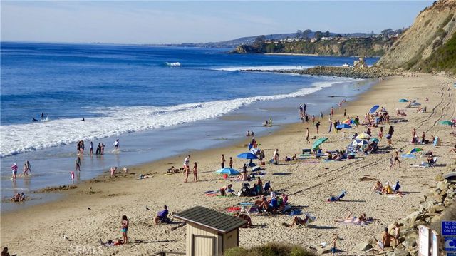 a vase of flowers sitting on a sand floor
