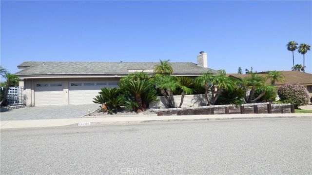 a front view of a house with a garden and mountain view