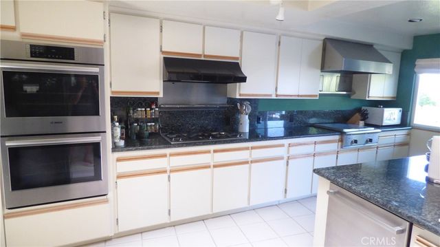a kitchen with granite countertop white cabinets stainless steel appliances and sink