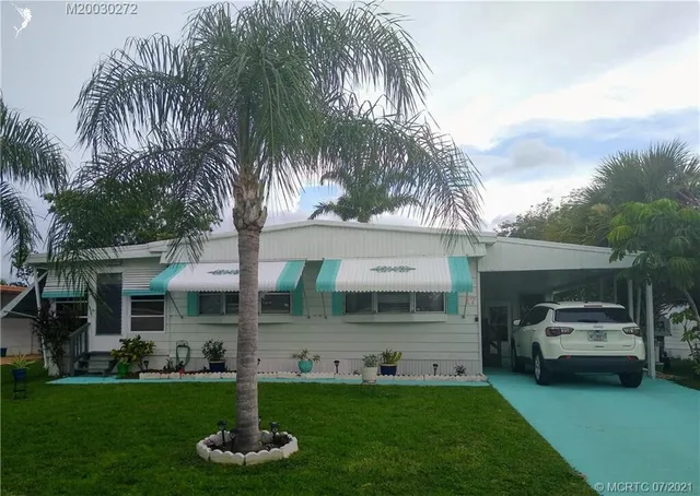 a front view of a house with a garden and trees