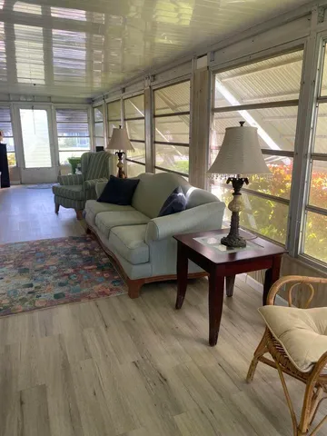 a living room with furniture and floor to ceiling windows