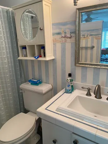a bathroom with a toilet a sink and a mirror
