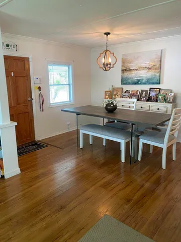 a living room with furniture wooden floor and a dining table
