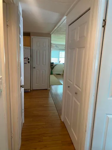 a view of a hallway with wooden floor and staircase