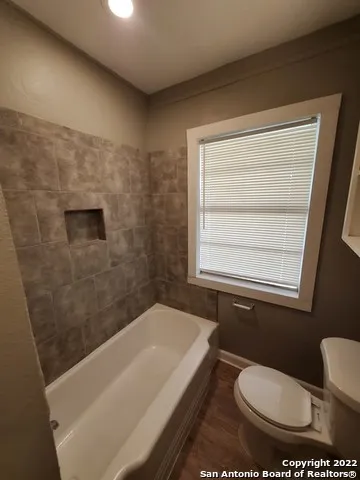 an empty room with windows and chandelier fan