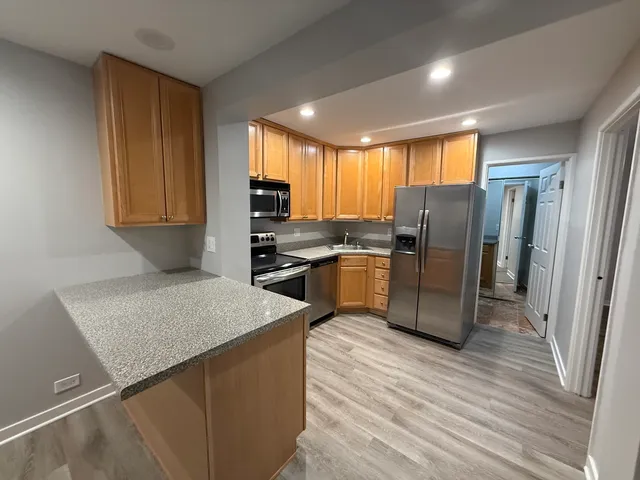 a kitchen with refrigerator cabinets and wooden floor