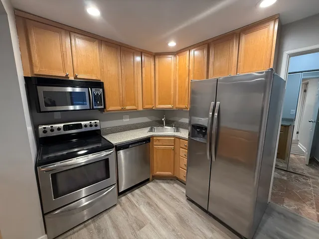 a kitchen with granite countertop a refrigerator stove and microwave