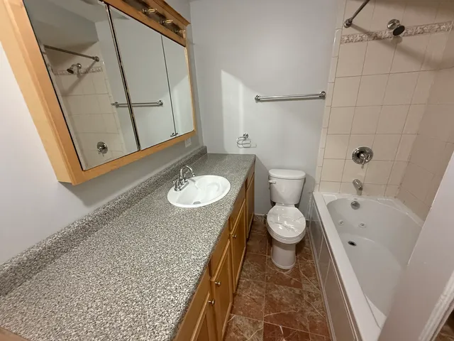 a bathroom with a granite countertop sink toilet a bathtub and a shower