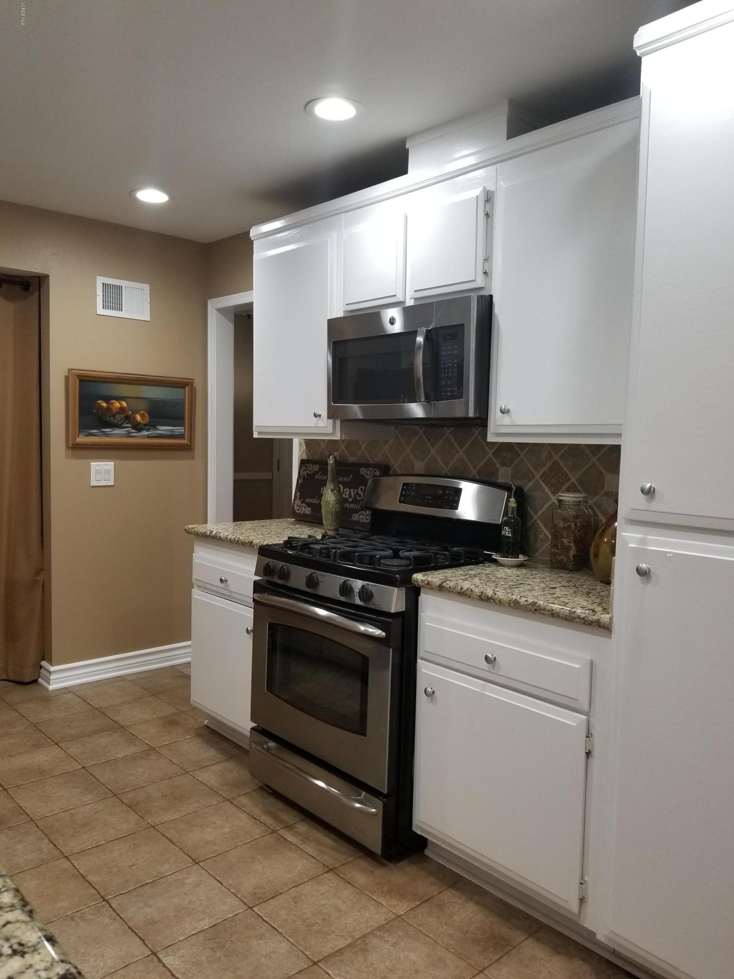 5727 Cochran Street Simi Valley, CA 93063 - Photo 18 of 43 a kitchen with stainless steel appliances granite countertop a stove a microwave and a refrigerator