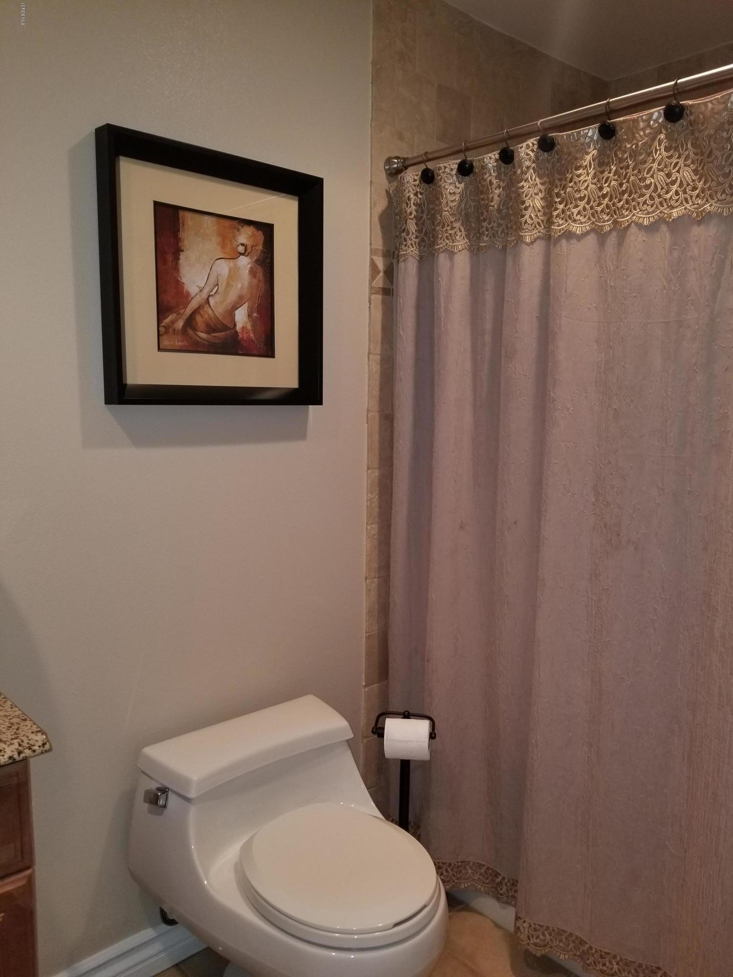 5727 Cochran Street Simi Valley, CA 93063 - Photo 36 of 43 a white toilet sitting next to a shower curtain