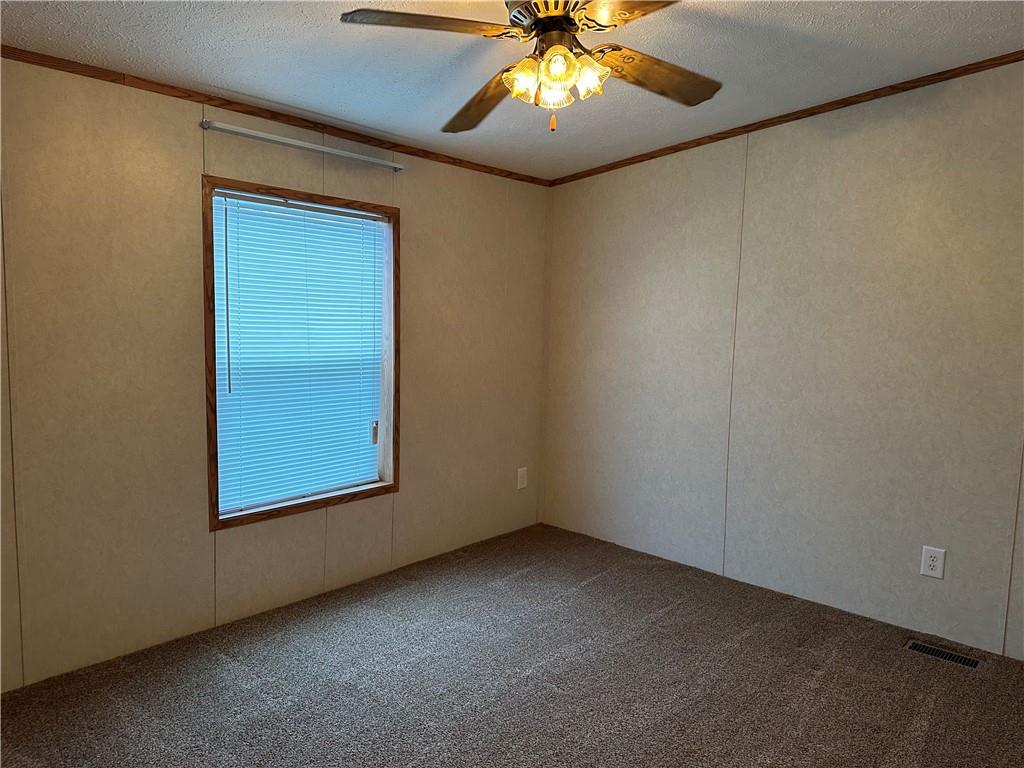107 Trieste Street Butler, PA 16002 - Photo 25 of 40 an empty room with a chandelier fan and wooden floor