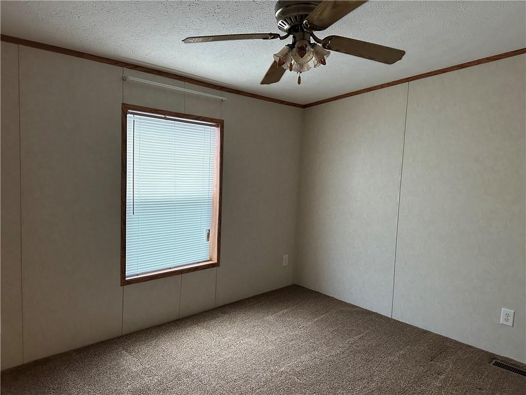 107 Trieste Street Butler, PA 16002 - Photo 26 of 40 an empty room with a chandelier fan and windows