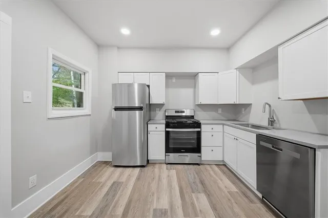 a kitchen with granite countertop a refrigerator stove top oven and sink