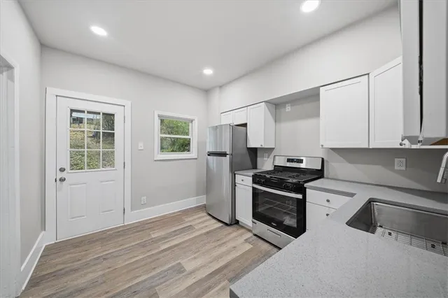 a kitchen with white cabinets and stainless steel appliances
