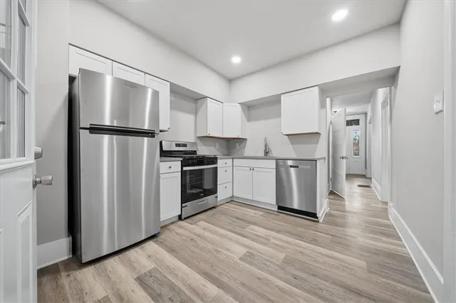 a kitchen with stainless steel appliances a refrigerator sink and cabinets