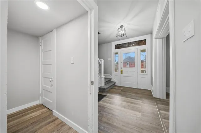 a view of a hallway with wooden floor and closet