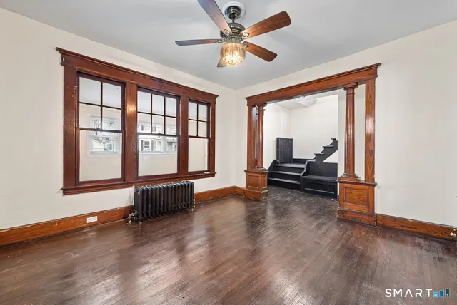 a living room with furniture and a large window with wooden floor