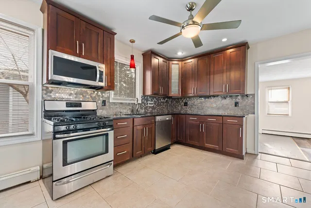 a kitchen with stainless steel appliances granite countertop a stove sink and microwave